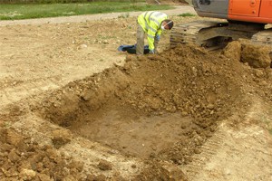 An Environment Agency officer sampling the waste soils near the river